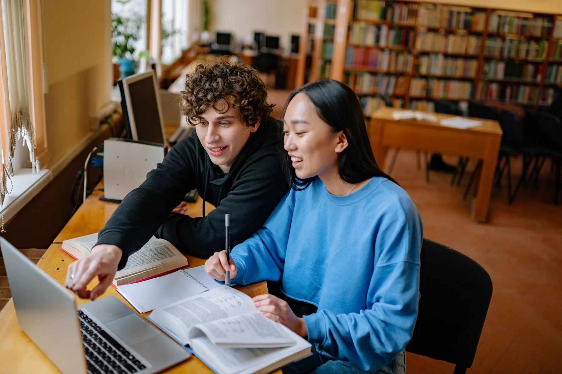 Students collaborating on academic work in a library